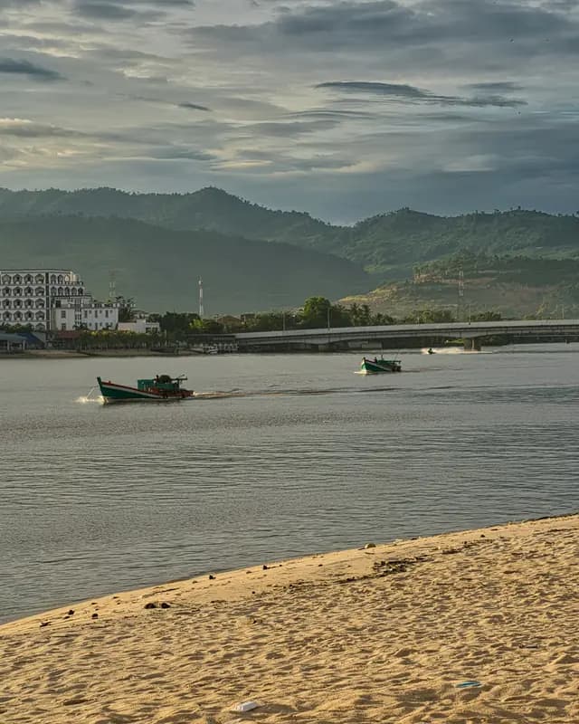 Boats on the Kampot River, with the town and hills behind